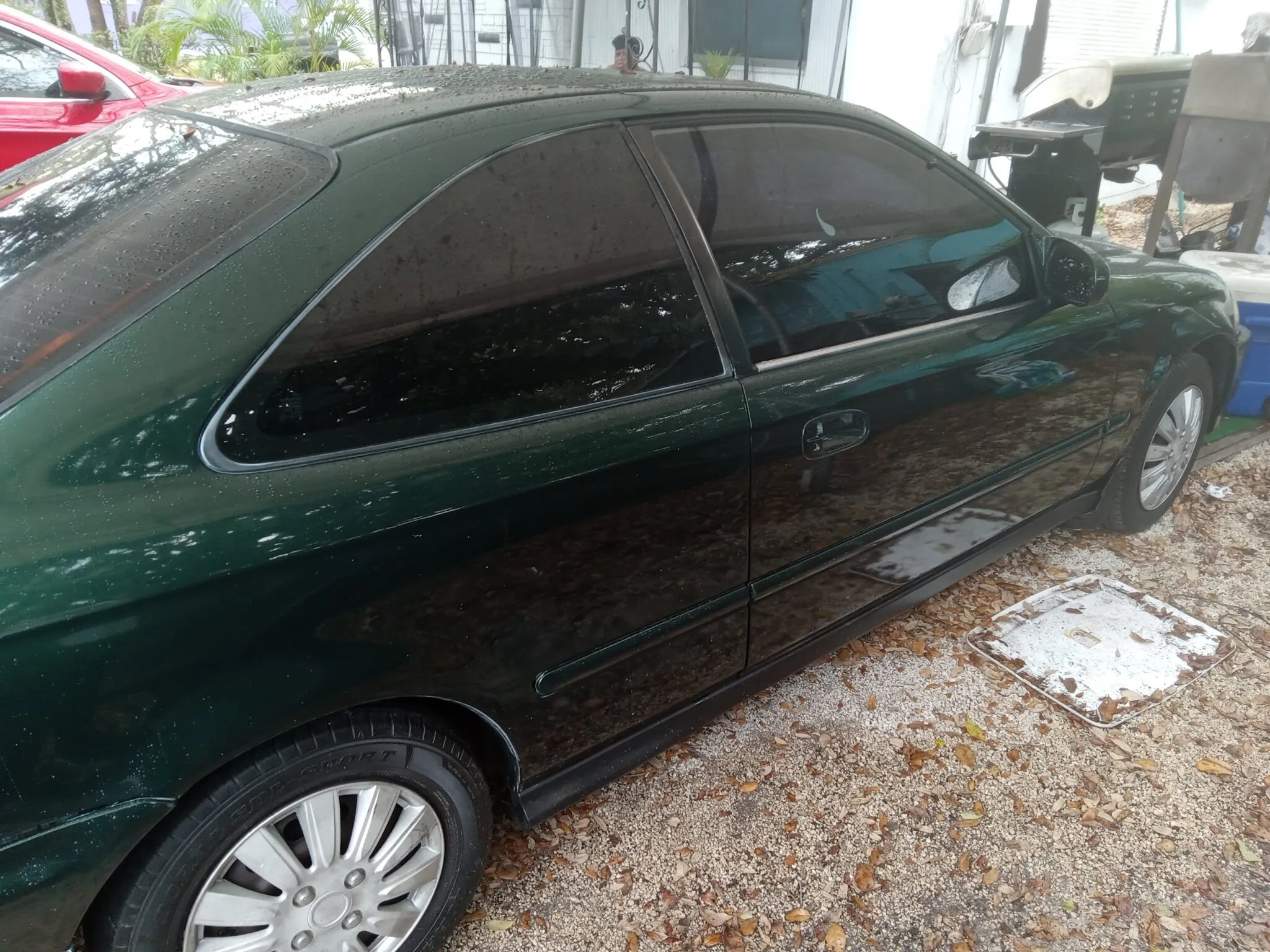 A car parked in a shaded area, promoting Honda Civic junk car buyer in Delray Beach.