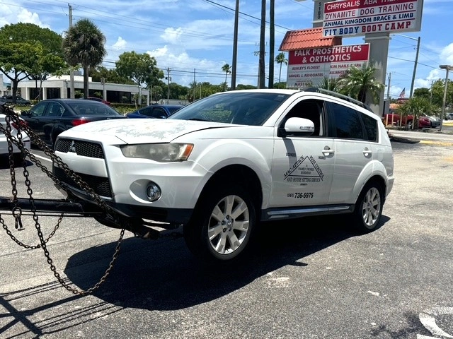 White SUV attached to a tow truck in a parking lot illustrating #1 Junk Car Buyer in Pompano Beach