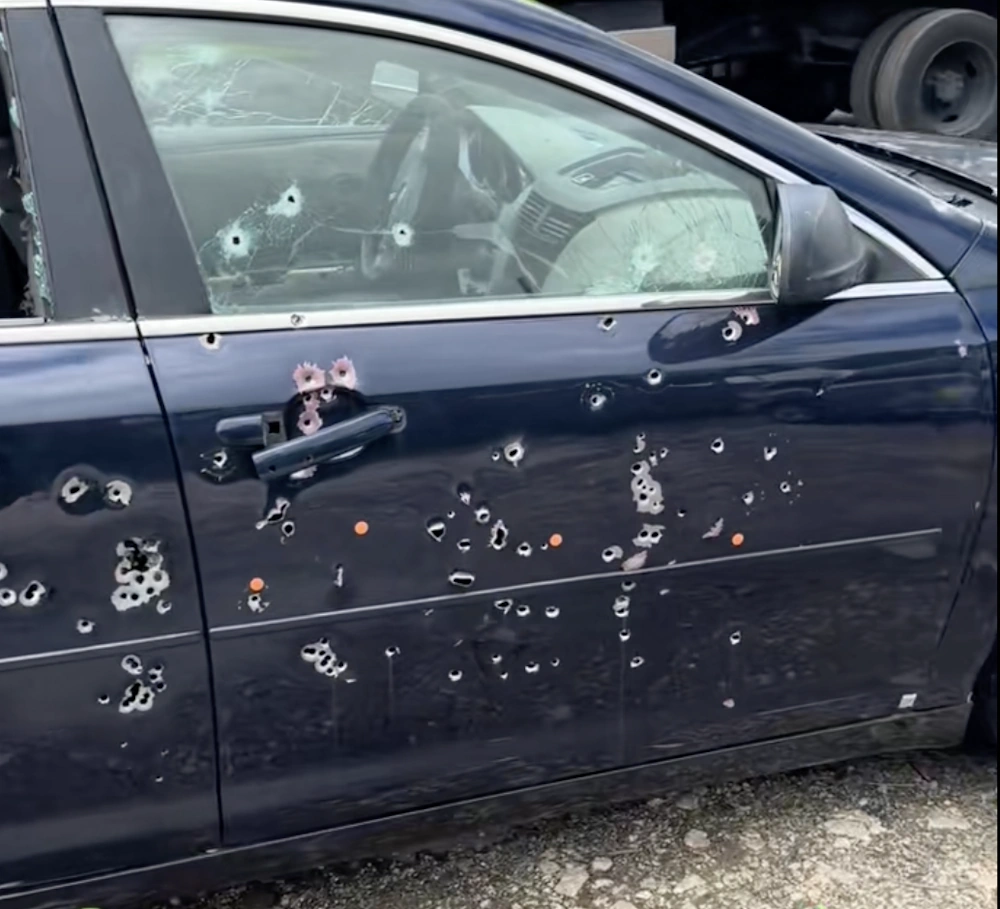 A Cash for Cars Miami with numerous bullet holes and damaged windows.