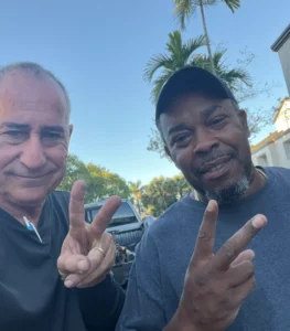 Two people making peace signs symbolizing the friendly service offered by Hercules’ We Buy Junk Cars in Sunny Isles Beach.