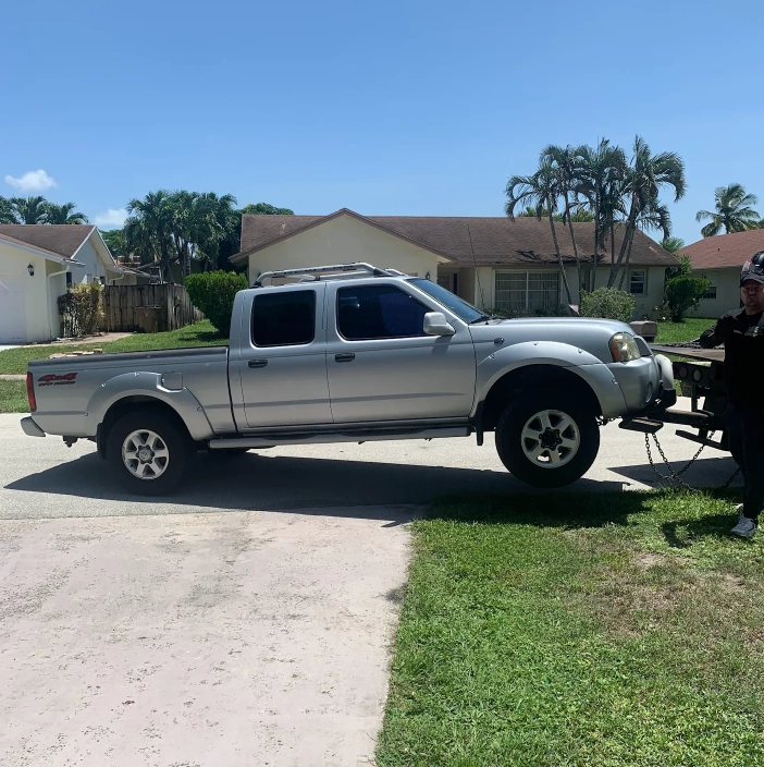 Tow truck hauling a pickup, illustrating how Hercules' We Buy Junk Cars in Cooper City handles vehicle removal.
