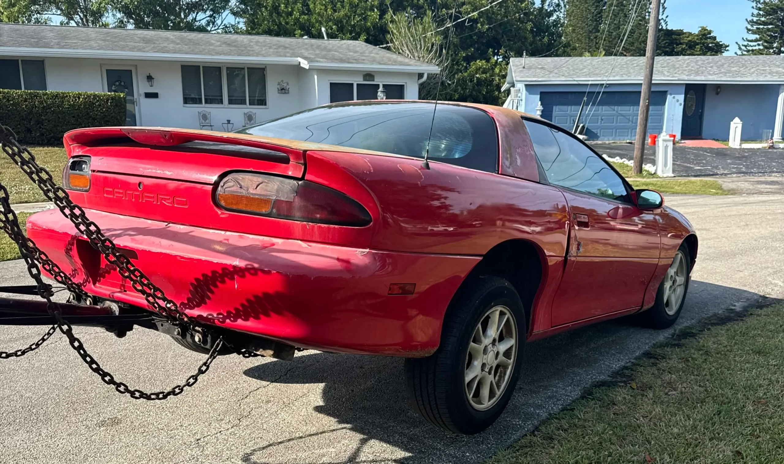 A red camaro being towed in Broward County