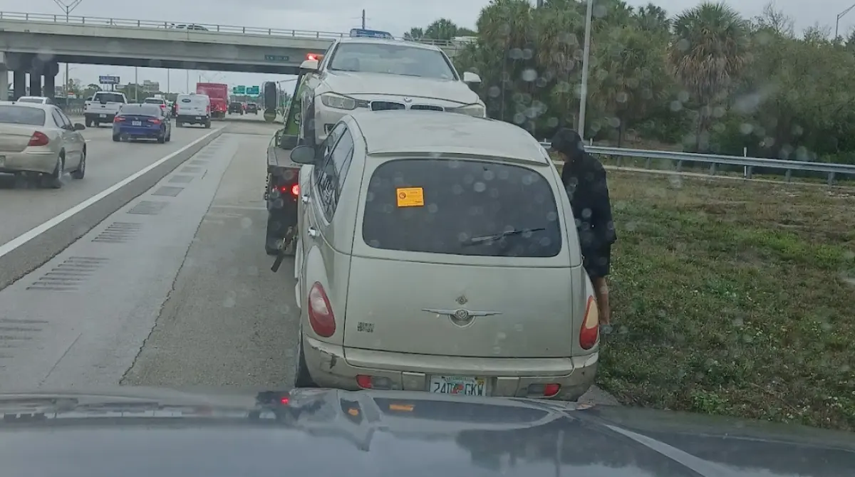 A broken-down Chrysler PT Cruiser being towed off the I-95 in Deerfield Beach by Hercules Buys Junk Cars.