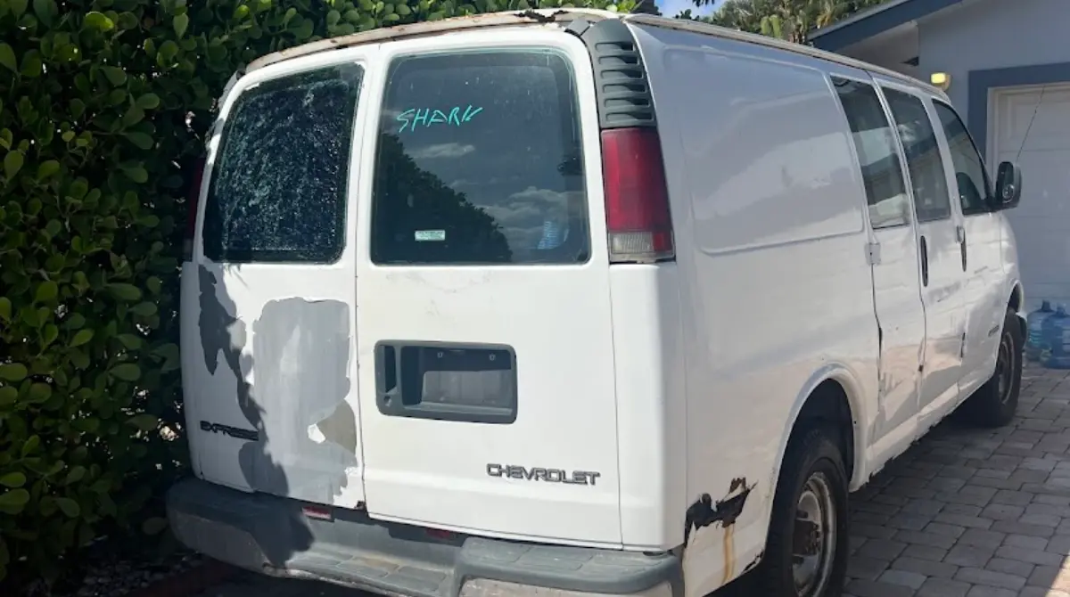 A Chevrolet Express van being evaluated for its original vs aftermarket catalytic converter scrap value by Hercules Buys Junk Cars in Deerfield Beach.